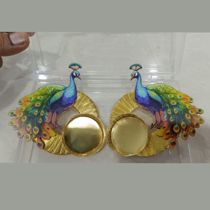 two decorative peacock-themed diya holders by kriti jain